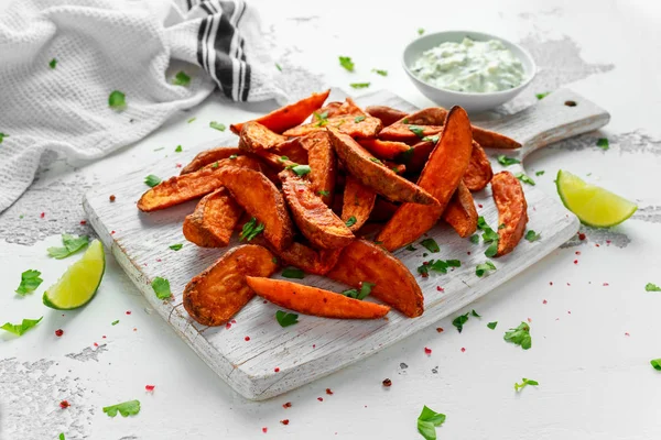 Caseiro saudável Baked Orange Sweet Potato cunhas com molho de creme fresco mergulho, ervas, sal e pimenta . — Fotografia de Stock