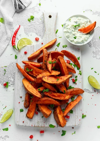 Caseiro saudável Baked Orange Sweet Potato cunhas com molho de creme fresco mergulho, ervas, sal e pimenta . — Fotografia de Stock