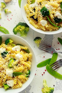 Makarna yeşil sebzeler brokoli, uyuz muhbir ve beyaz tabak içinde krem sos ile