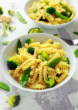 Makarna yeşil sebzeler brokoli, uyuz muhbir ve beyaz tabak içinde krem sos ile