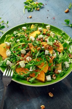 Taze roka, fındık, beyaz peynir, zeytinyağı ve otlar ile lezzetli Trabzon hurması salata. sağlıklı gıda