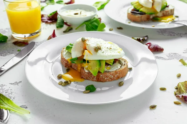 Sanduíche, torrada com abacate, queijo mole e ovo escalfado sobre fundo branco — Fotografia de Stock