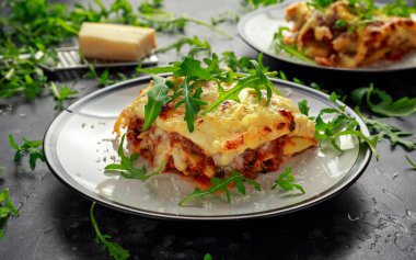 Ev yapımı lazanya kıyma bolognese ve Beşamel sos tepesinde vahşi roka, parmesan peyniri ile