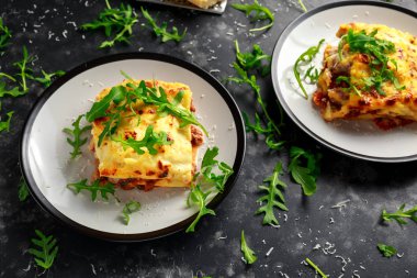 Ev yapımı lazanya kıyma bolognese ve Beşamel sos tepesinde vahşi roka, parmesan peyniri ile