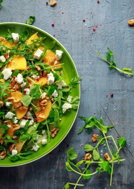 Taze roka, fındık, beyaz peynir, zeytinyağı ve otlar ile lezzetli Trabzon hurması salata. sağlıklı gıda