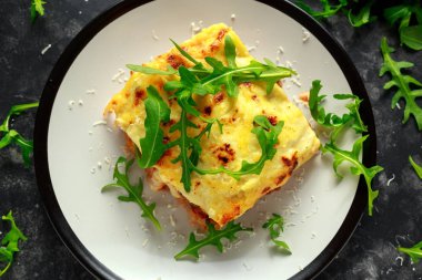 Ev yapımı lazanya kıyma bolognese ve Beşamel sos tepesinde vahşi roka, parmesan peyniri ile