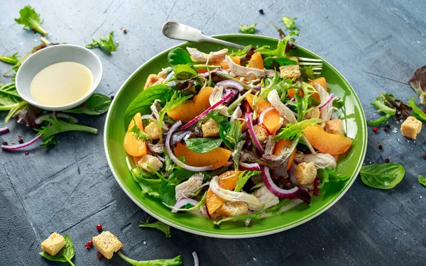 Свежий салат с куриной грудкой, персиком, красным луком, гренками и овощами в зеленой тарелке. здоровое питание — стоковое фото