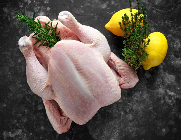 Whole raw Free range chicken in rustic background with rosemary leaf, thyme, lemon. ready to cook — Stock Photo, Image