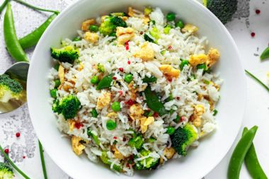 Sebzeler, brokoli, bezelye ve beyaz bir kase yumurta kızarmış pirinç. soya sosu. sağlıklı gıda