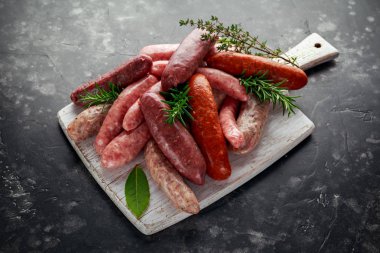 Taze çiğ doğurmak kasaplar sosis mix derileri beyaz kesme tahtası üzerinde otlar ile yapılan.