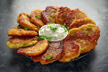 Patates gözlemesi, draniki, kıymalı patates veya börek taze krema ve soğan ile servis