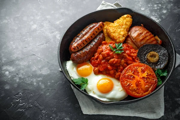 완전 한 영어 아침 식사 베이컨, 소시지, 계란, 구운된 콩, 감자와 버섯 소박한 프라이팬, 냄비. — 스톡 사진