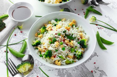 Sebzeler, brokoli, bezelye ve beyaz bir kase yumurta kızarmış pirinç. soya sosu. sağlıklı gıda