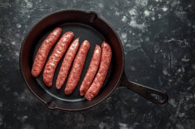 Taze çiğ doğurmak rustik tavada kasaplar sosis yaptı.