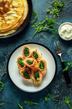 Füme somon ile taze Creme tabakta vahşi roket salata dolgu ile doldurulmuş krep krep rulo