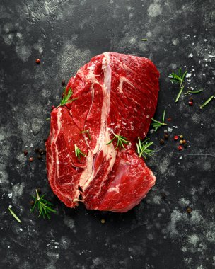 Biberiye, karabiber, tuz ile siyah arka plan üzerine biftek salata soslarında taze Raw