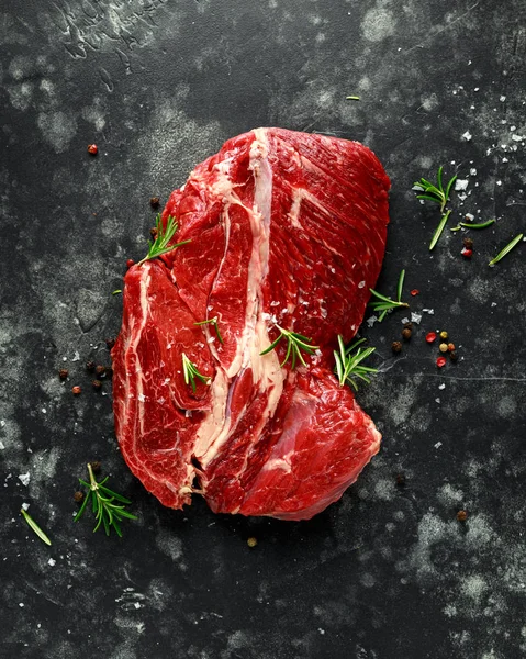 Filete crudo fresco de estofado sobre fondo negro con romero, pimienta, sal — Foto de Stock