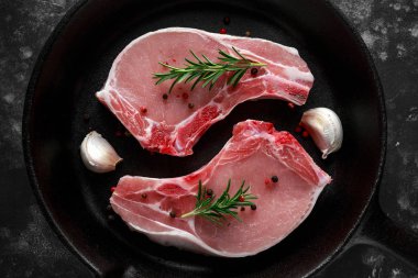 Çiğ domuz Loin pirzola rustik tava, biberiye, sarımsak, biber ile pan. Üstten Görünüm. arka plan