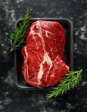 Rosemary ile siyah tepsisindeki biftek salata soslarında taze Raw.