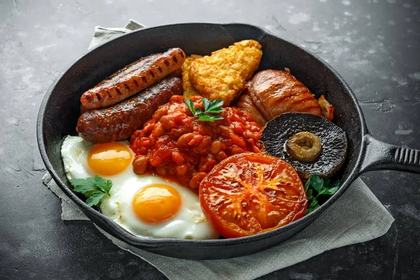 완전 한 영어 아침 식사 베이컨, 소시지, 계란, 구운된 콩, 감자와 버섯 소박한 프라이팬, 냄비. — 스톡 사진