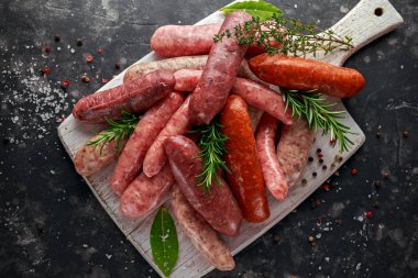Taze çiğ doğurmak kasaplar sosis mix derileri beyaz kesme tahtası üzerinde otlar ile yapılan.