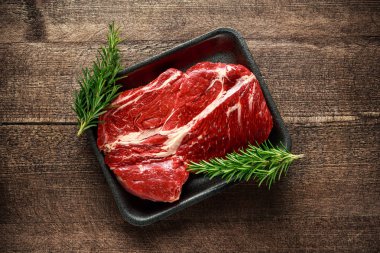 Rosemary ile siyah tepsisindeki biftek salata soslarında taze Raw.