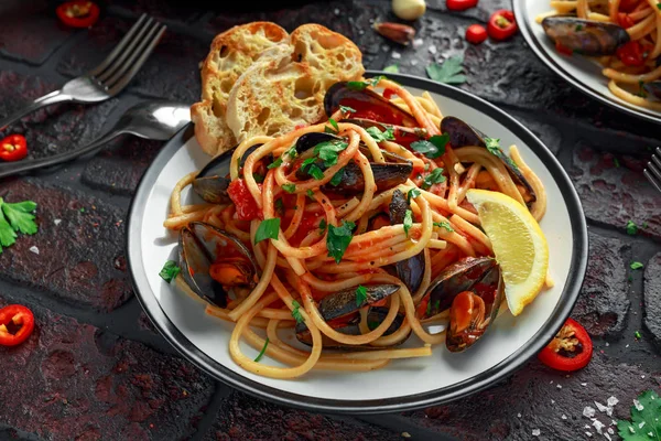 Homemade Pasta Spaghetti with mussels, tomato sauce, chilli and parsley on rustic background. sea food meal — Stock Photo, Image