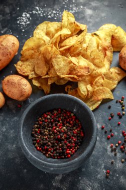 Kaymaklı biber patates cipsi, pişmiş cips taş tahta üzerinde deniz tuzu ile mermer havaneli ve harç ile snack.