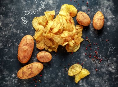 Kaymaklı biber patates cipsi, pişmiş cips taş tahta üzerinde deniz tuzu ile mermer havaneli ve harç ile snack.
