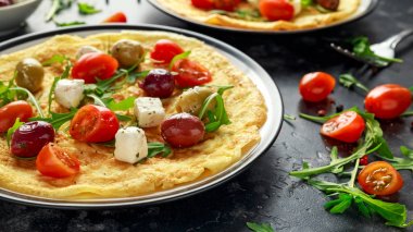 Domates, vahşi roket, Yunan peynir, zeytin bir plaka ile sebze yumurta omlet. Sabah kahvaltı. sağlıklı gıda