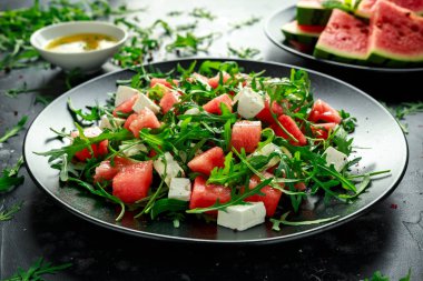 Taze sulu karpuz roka nane ile beyaz peynir salatası ve portakal, limon sosu. yaz yemek. sağlıklı gıda