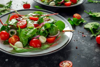 Taze kiraz domates, Mozzarella salatası yeşil salata karışımı ve kırmızı soğan ile. tabakta. sağlıklı gıda.
