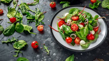 Taze kiraz domates, Mozzarella salatası yeşil salata karışımı ve kırmızı soğan ile. tabakta. sağlıklı gıda.