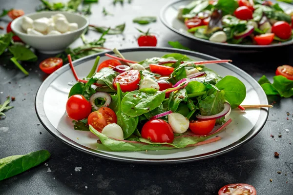Свежий вишневый помидор, салат Моцарелла с зеленым салатом и красный лук. подается на тарелке. здоровое питание . — стоковое фото
