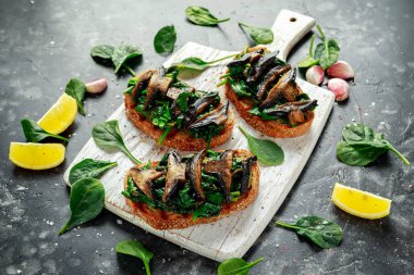 Mushrooms and garlic sauteed spinach toasts With lemon wedges. healthy food. clipart