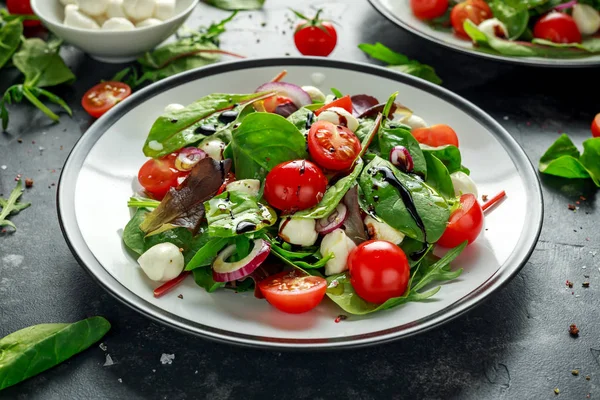 Свіжий вишневий помідор, салат Моцарелла з зеленим салатом і червоною цибулею. подається на тарілці. здорова їжа . — стокове фото