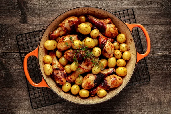 Baguettes de poulet cuites au four et patates douces au thym dans une casserole, prêtes à servir — Photo