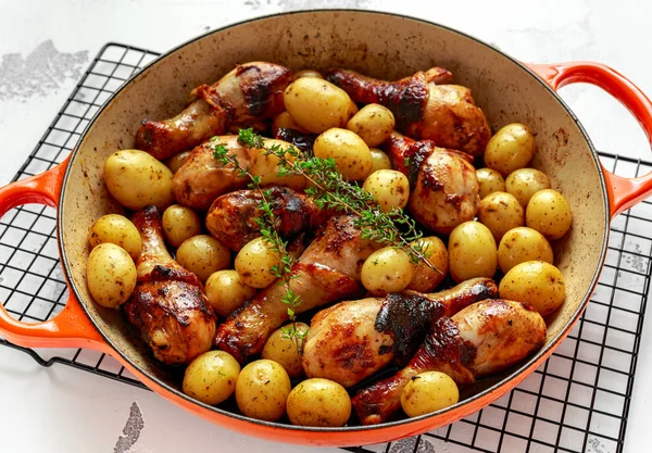Baguettes de poulet cuites au four et patates douces au thym dans une casserole, prêtes à servir — Photo