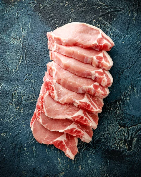 Côtelettes de longe de porc crues sur fond bleu — Photo