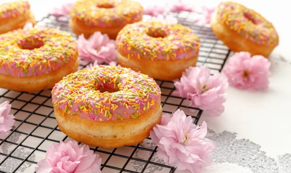 Sweet pink fresh Donut decorated with japanese Flowering Cherry Tree flower — Stock Photo, Image