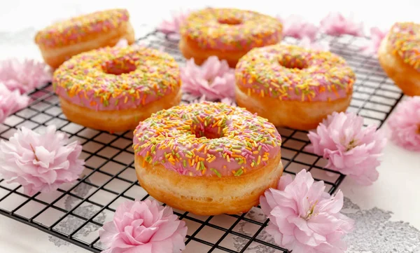 Sweet pink fresh Donut decorated with japanese Flowering Cherry Tree flower — Stock Photo, Image