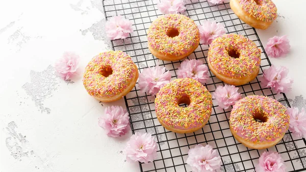 Sweet pink fresh Donut decorated with japanese Flowering Cherry Tree flower — Stock Photo, Image