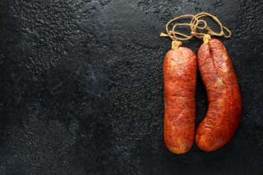 geleneksel Balear çiğ et sobrassada sosis zemin domuz eti, kırmızı biber ve rustik siyah arka plan üzerinde baharat yapılmış