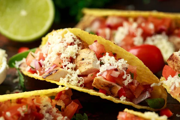 chicken tacos with salsa, cheese and corn tortila