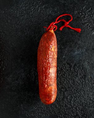 geleneksel Balear çiğ et sobrassada sosis zemin domuz eti, kırmızı biber ve rustik siyah arka plan üzerinde baharat yapılmış