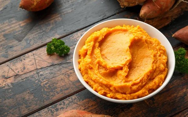 Mashed Sweet Potatoes in white bowl on wooden rustic table. Healthy food — Stock Photo, Image