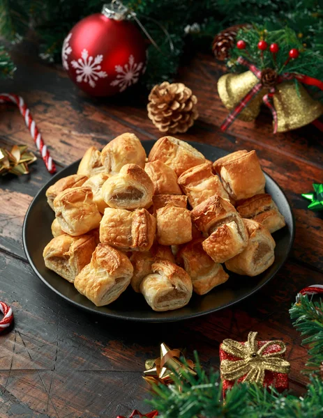 Christmas Sausage Rolls with decoration, gifts, green tree branch on wooden rustic table — Stock Photo, Image