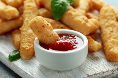 Çıtır Halloumi peyniri, beyaz tahta üzerinde acı soslu patates kızartması.