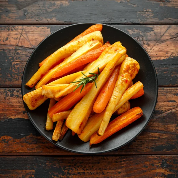 Panggang Parsnips and Carrots with herbs on rustic wood table — Stok Foto