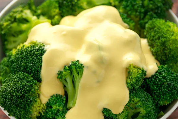 Brócoli con salsa de queso en tazón blanco sobre mesa de madera — Foto de Stock